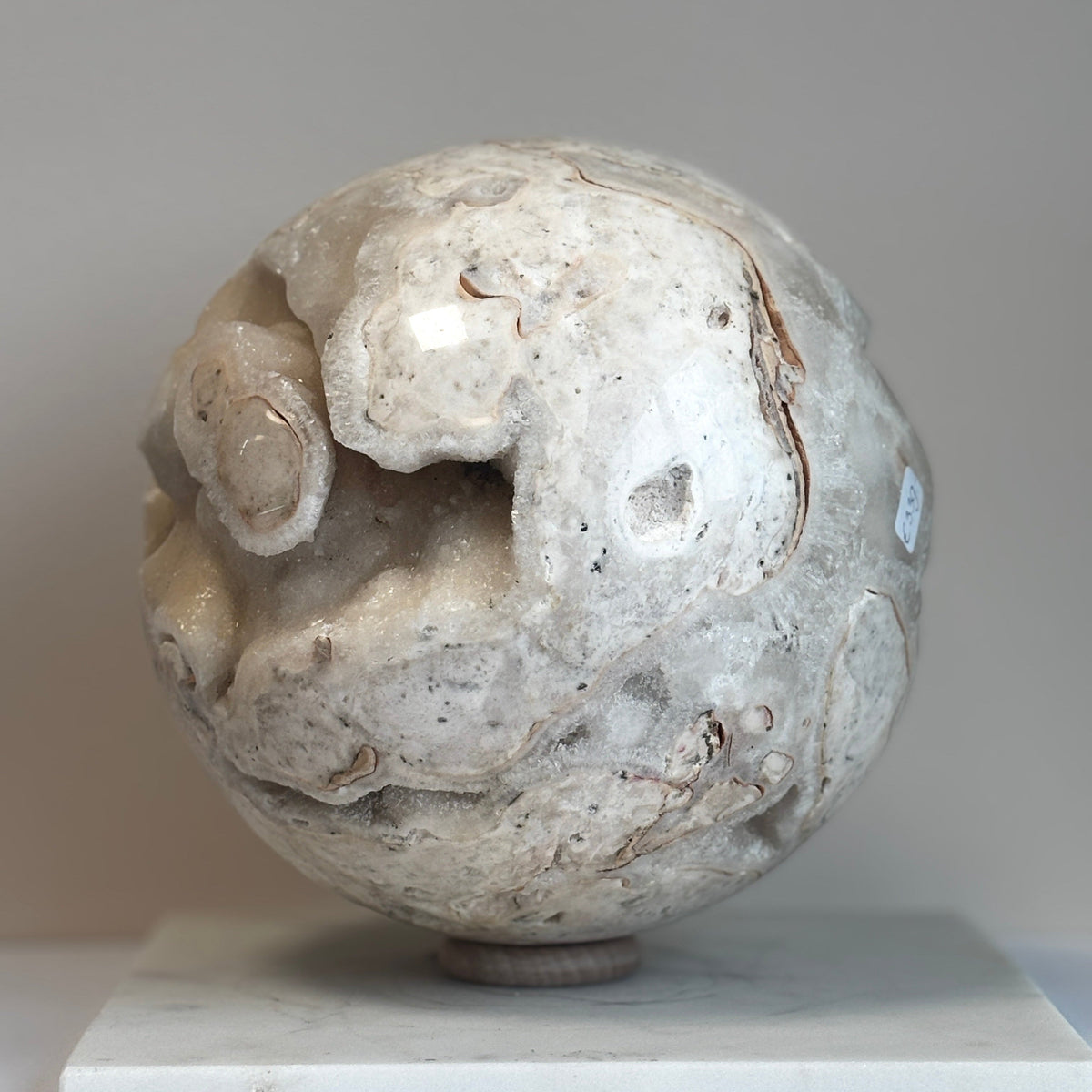 Witte calciet bol van circa 18 cm met natuurlijke kristalopeningen