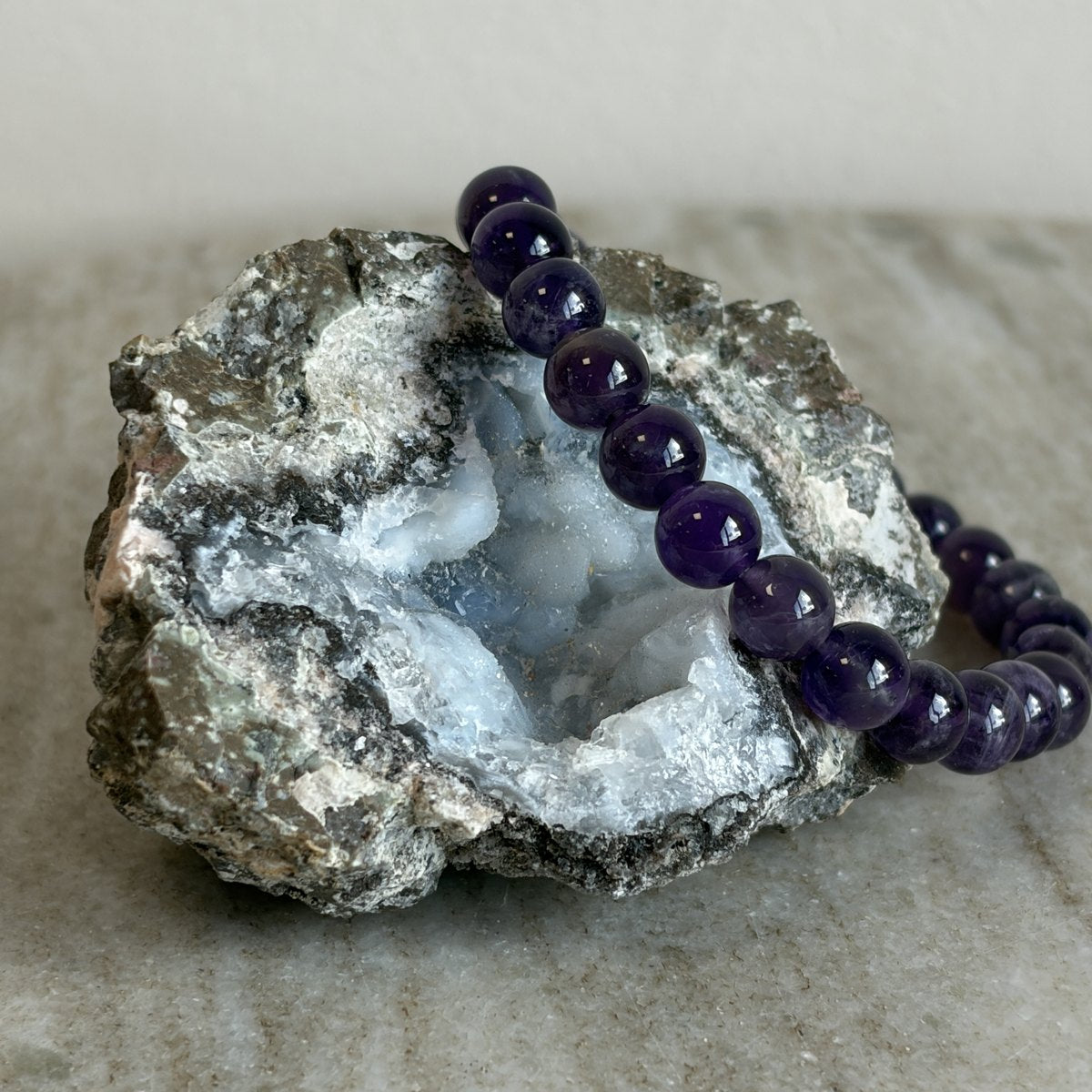 Amethist kinderarmband met paarse 6 mm kralen op een geode