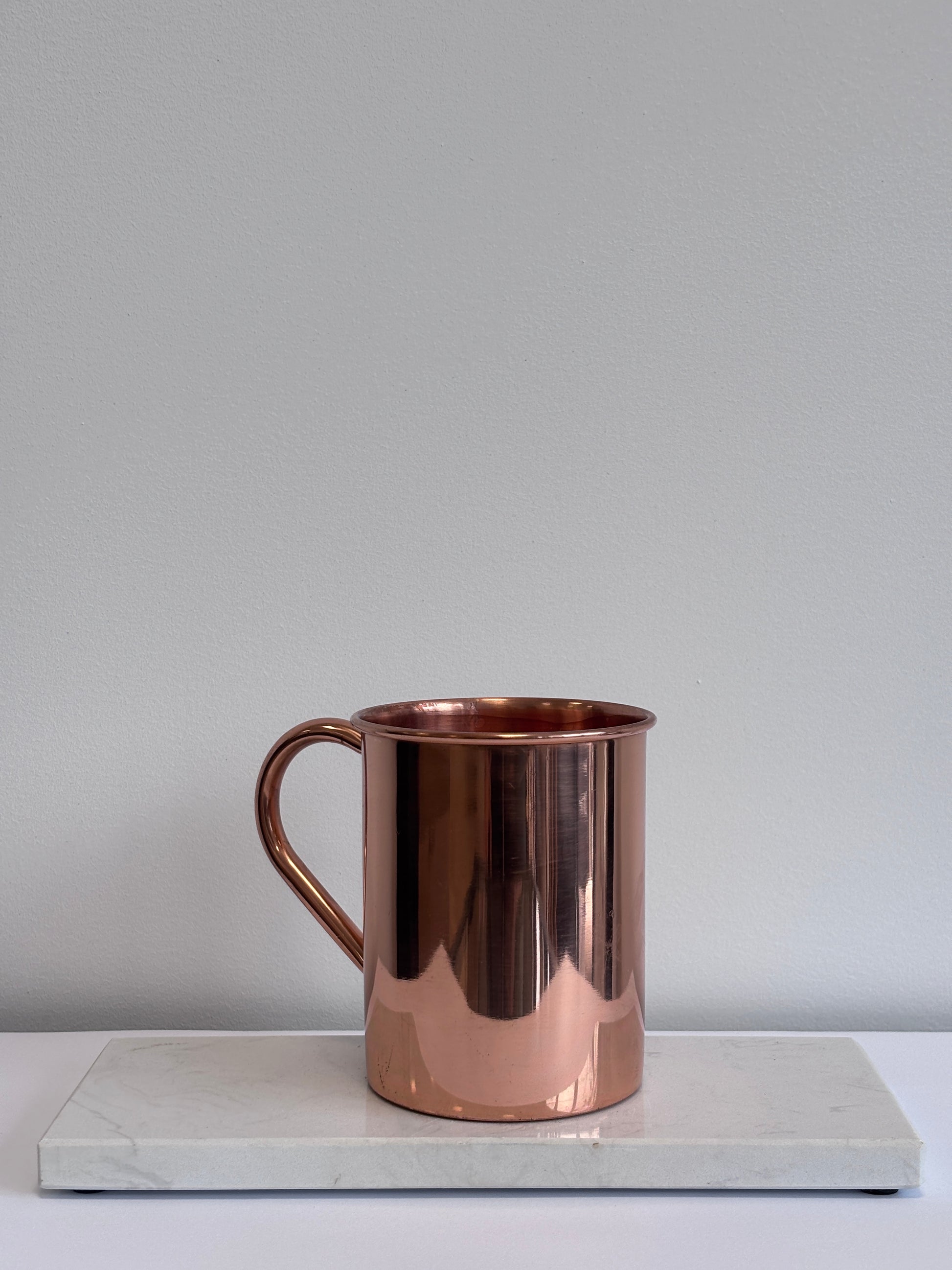 Ayurvedisch ritueel – bewust water drinken uit koperen mok met mandala, bevordert vitaliteit