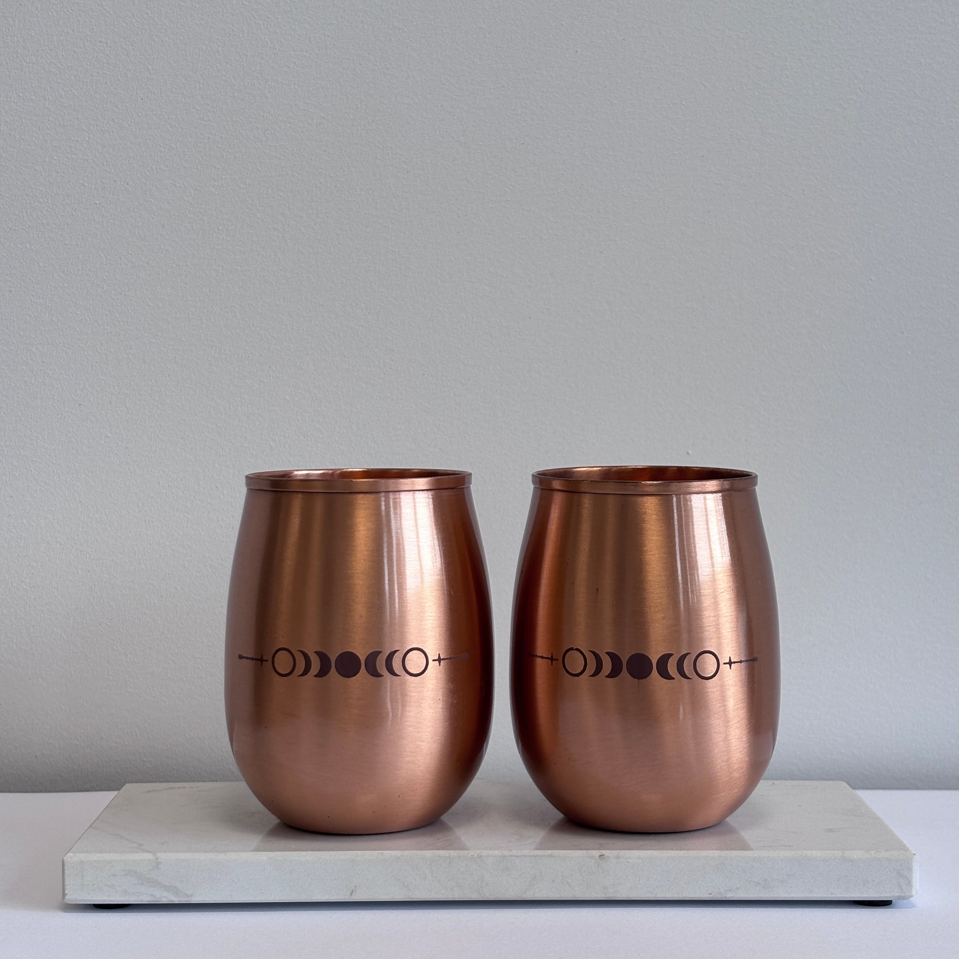 Detail van maanfasen-lasergravure op gepolijste koperen drinkbeker – symboliek van cyclus en balans