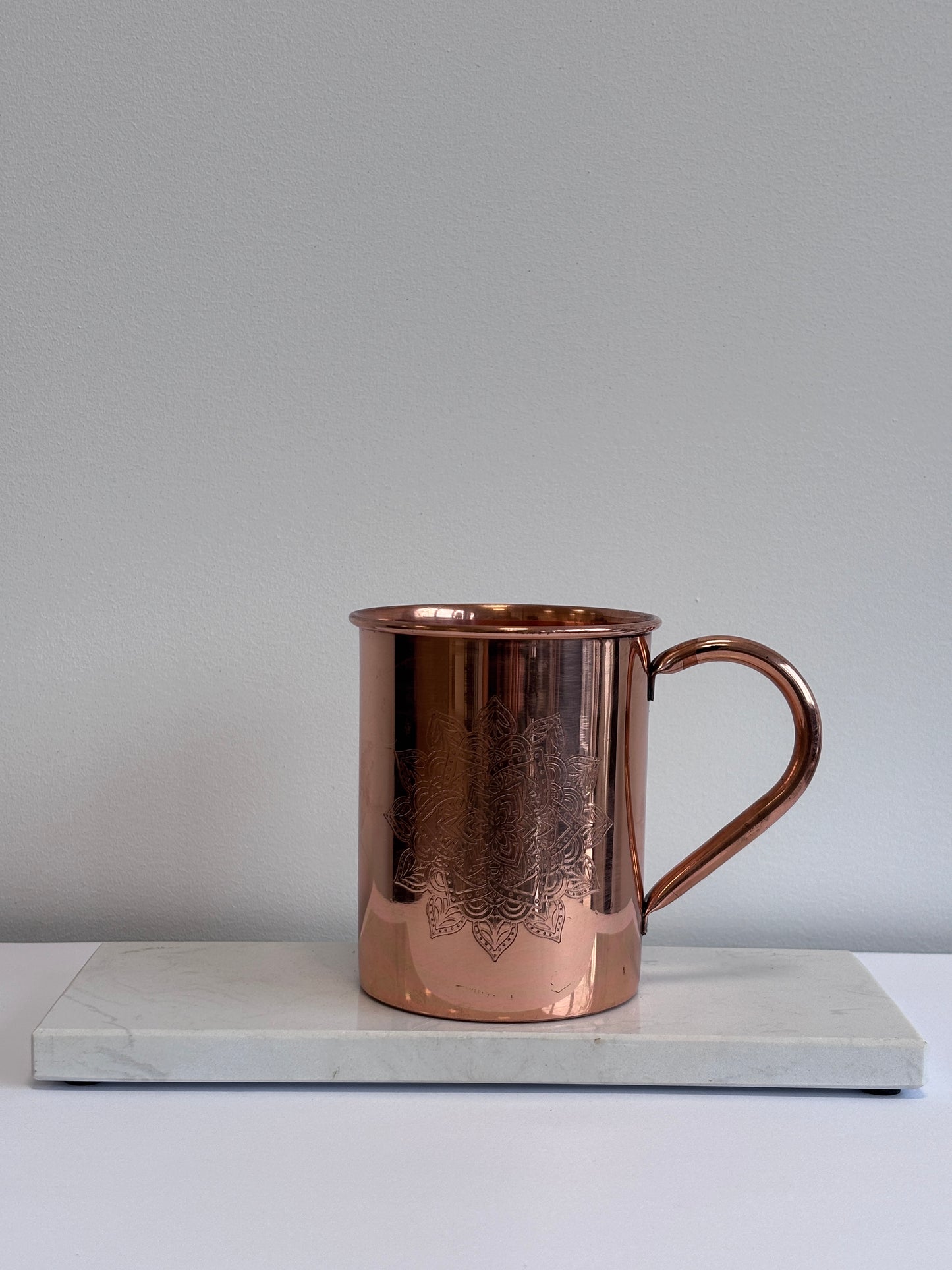 Close-up van het geëtste mandala-motief op gepolijste koperen mok – symbool voor harmonie en balans

Foto 3 (gebruikssituatie):