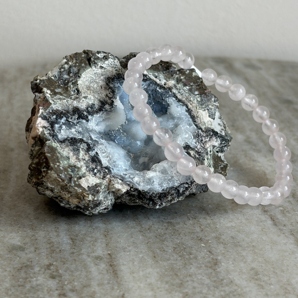 Rozenkwarts kinderarmband met zacht roze 4 mm kralen op een geode