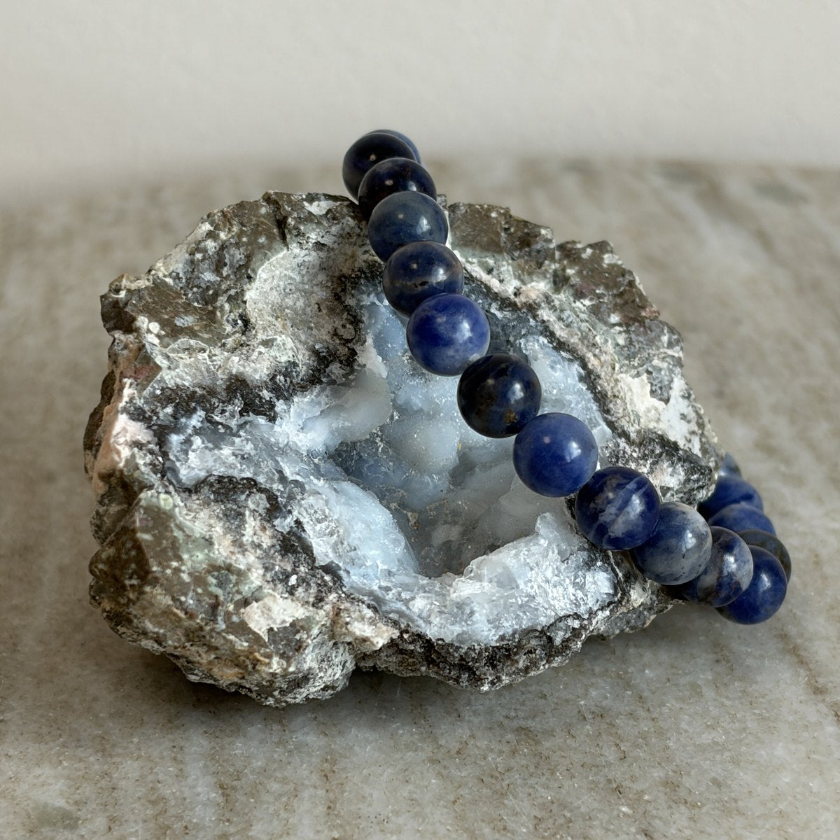 Sodaliet kinderarmband met blauwe 6 mm kralen op een geode