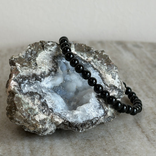 Zwarte toermalijn kinderarmband met 4 mm kralen op een geode